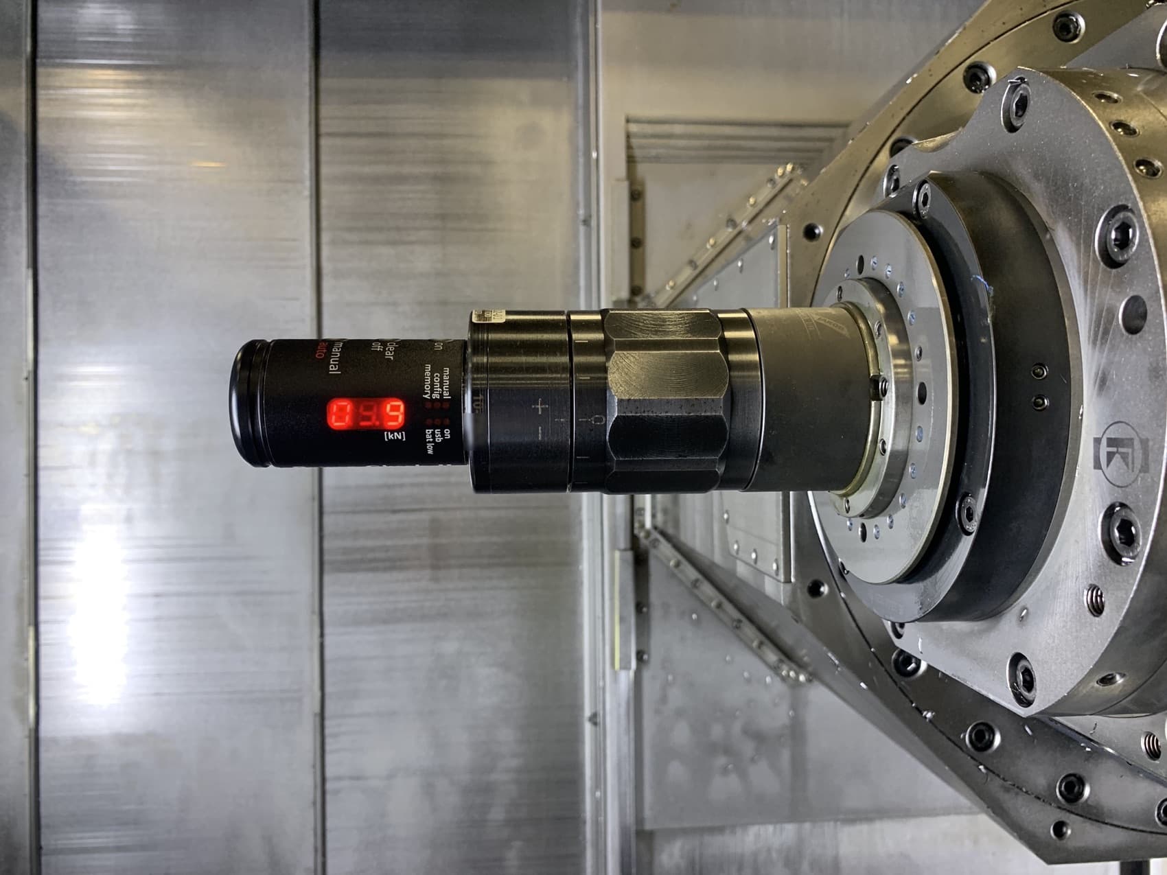 Spindle drawbar clamp force measured with a digital gauge inside a CNC machine during service.
